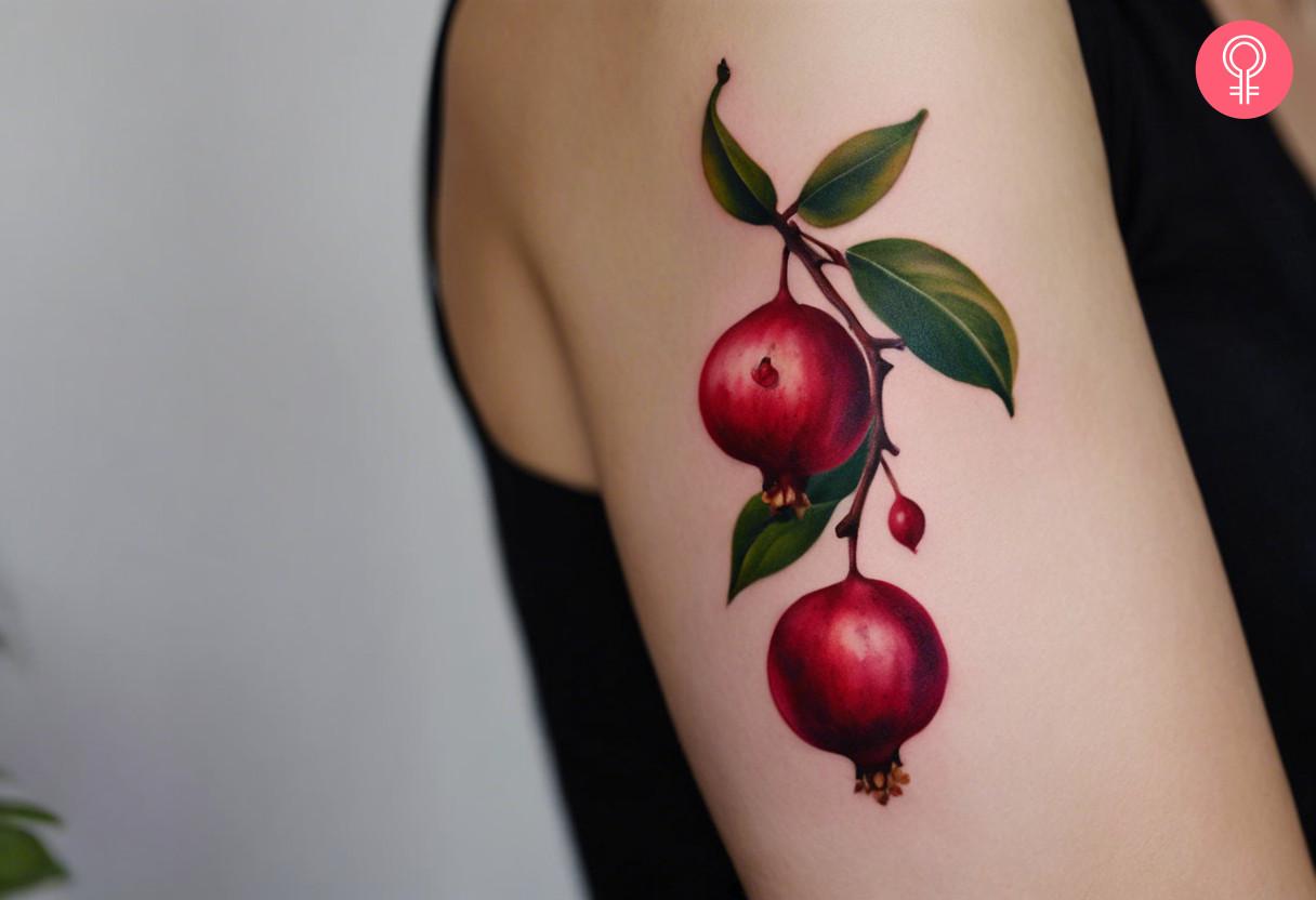 Pomegranate branch tattoo on a woman's arm