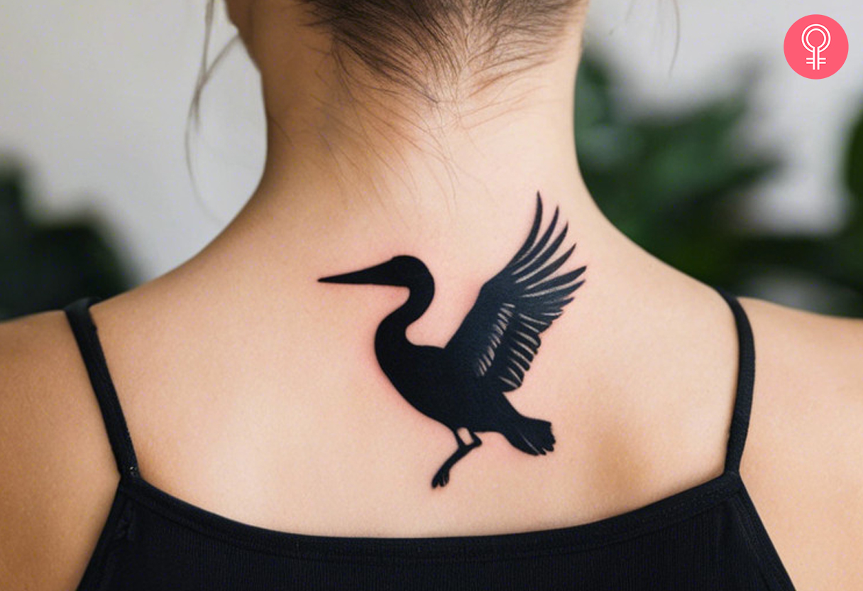 A silhouette tattoo of a Pelican on the back of the neck