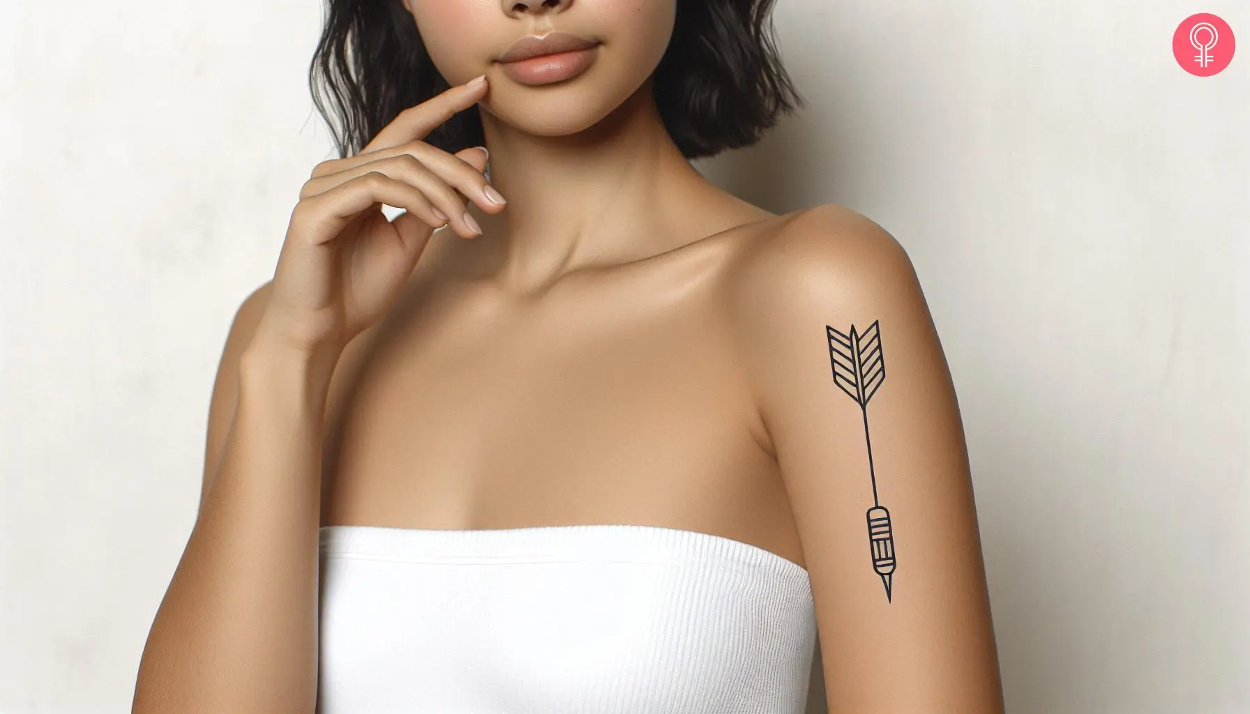 Woman with a simple dart tattoo on the upper arm