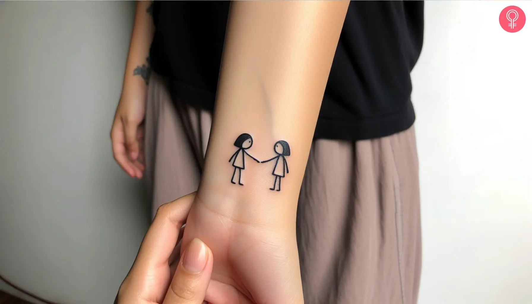 Woman with sister stick figure tattoo on her wrist