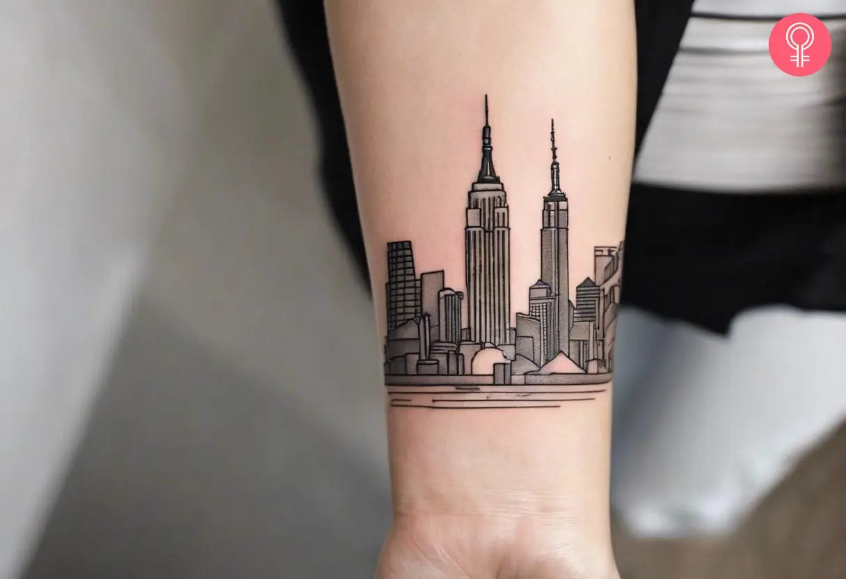 A New York skyline tattoo on the forearm of a woman