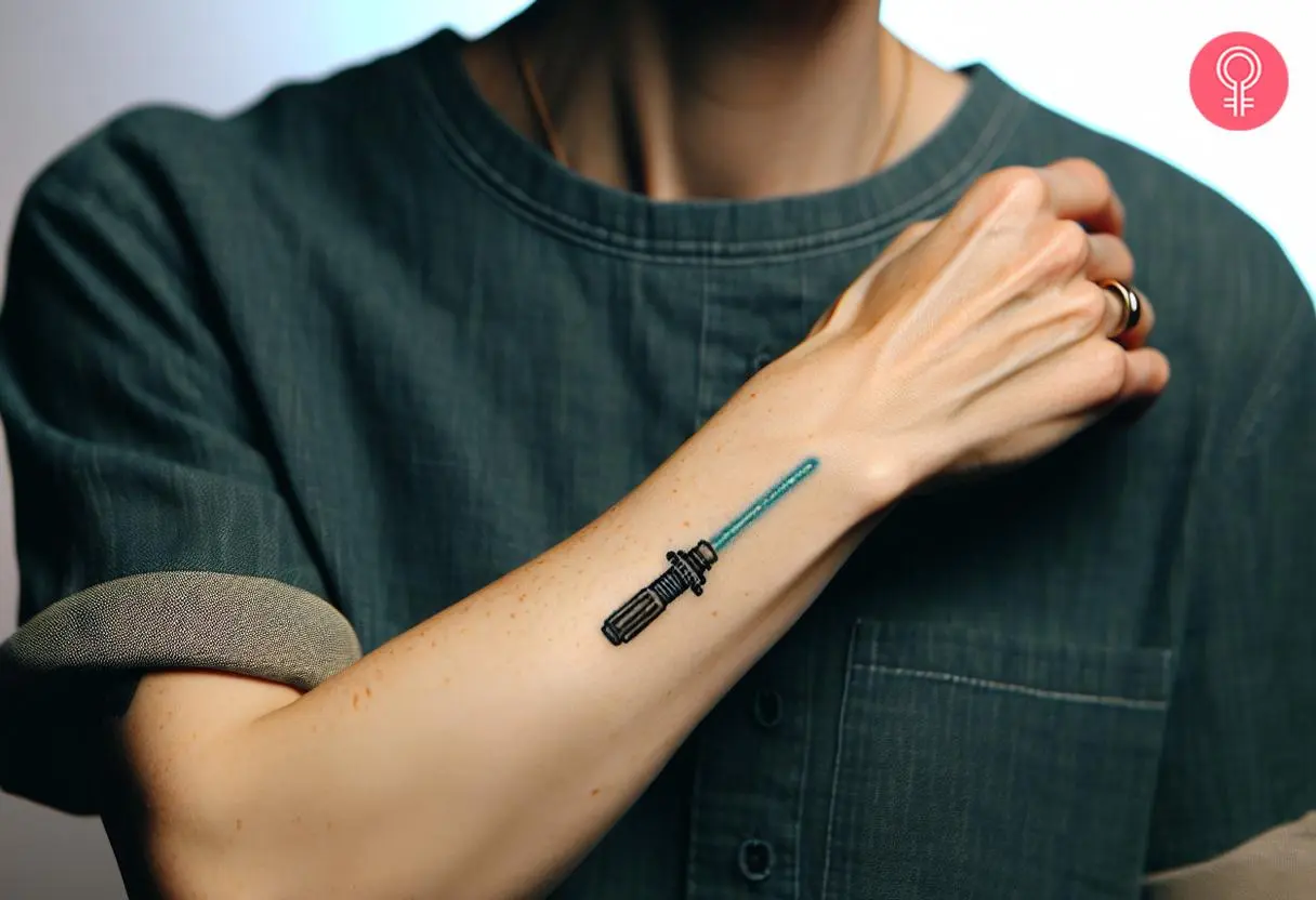 Small Lightsaber tattoo on a woman’s forearm