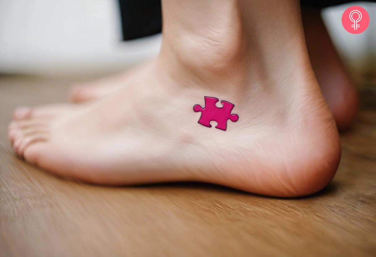 A cute and small pink puzzle piece tattoo on the ankle