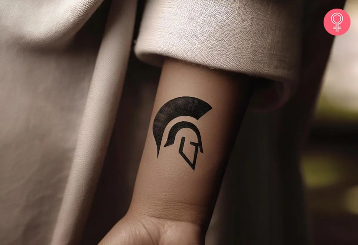 Small spartan helmet tattoo on a woman’s arm