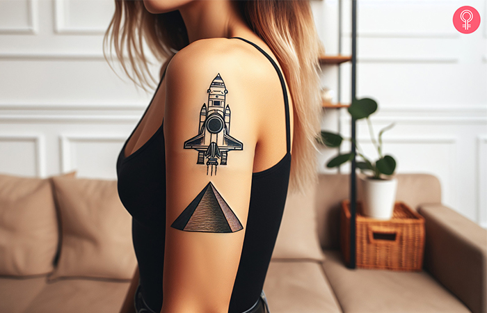 Spaceship and pyramid tattoo on the upper arm of a woman