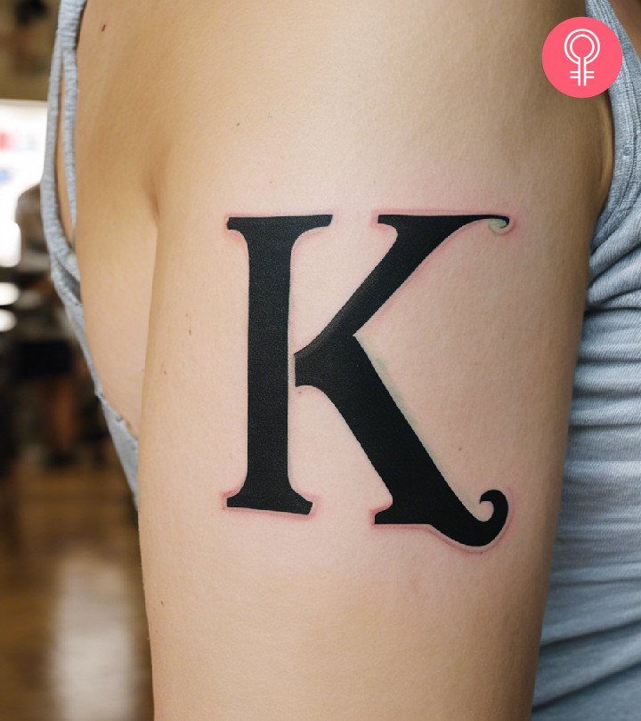 Letter K tattoo on the upper arm