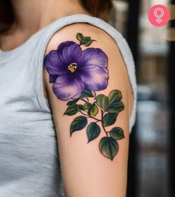 A woman with a purple-violet tattoo on her upper arm