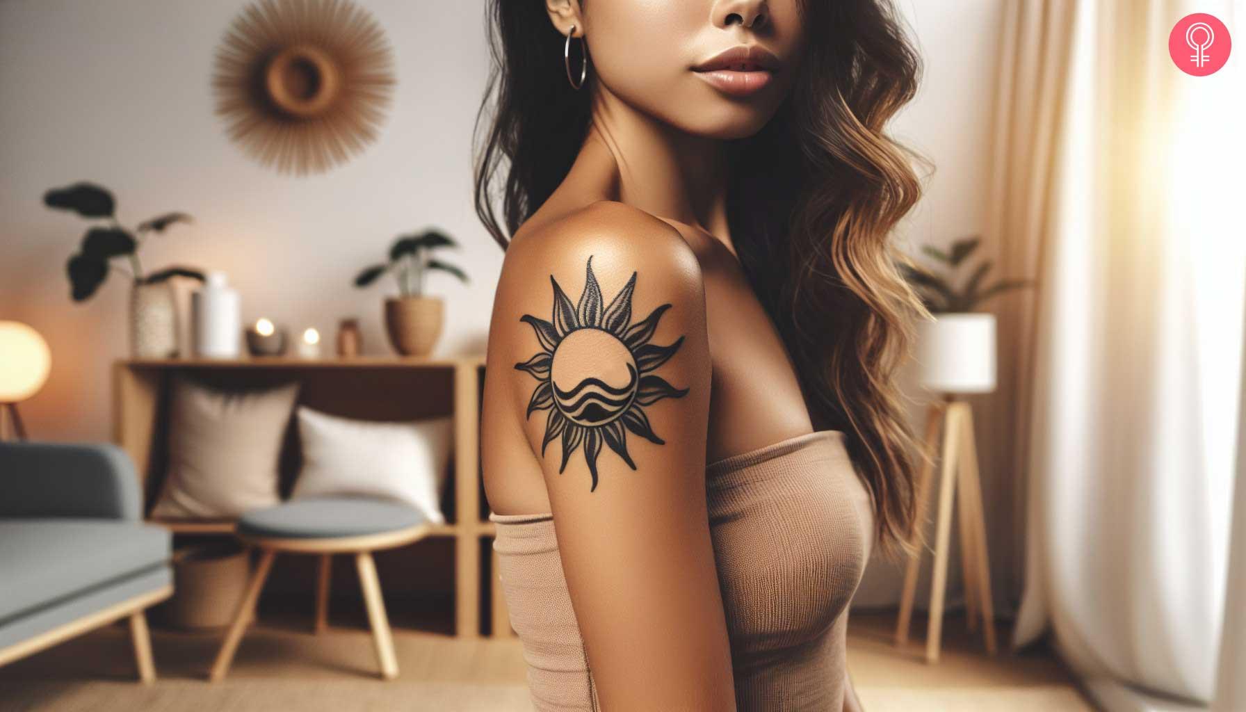 Sun and wave tattoo on the upper arm of a woman