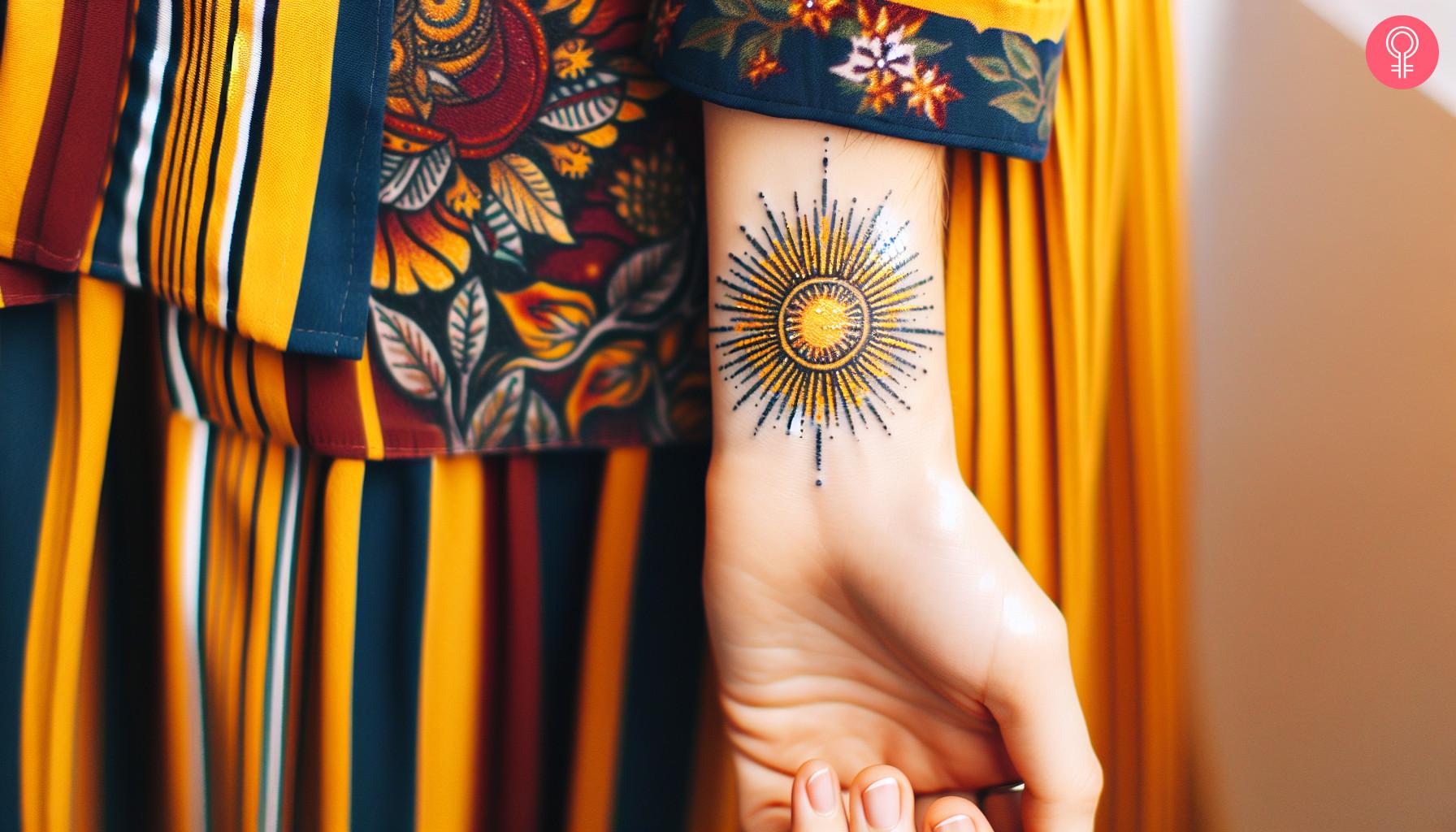 A sunshine tattoo on the wrist of a woman