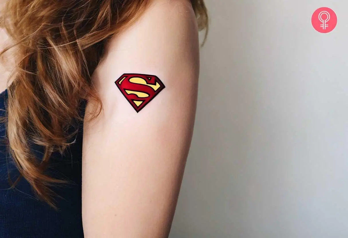 Superman emblem tattoo on a woman’s upper arm