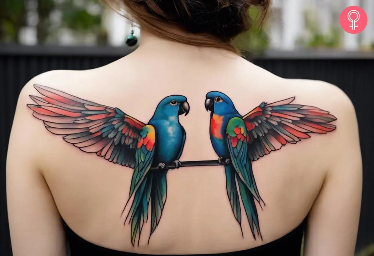 Symmetrical bird tattoo on the upper back of a woman