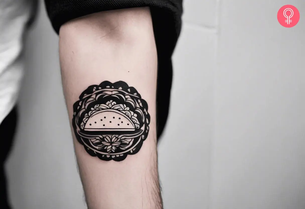 Black and white ink taco tattoo on the forearm of a man