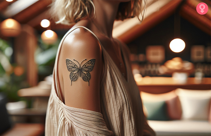 Thin line butterfly tattoo on the upper arm