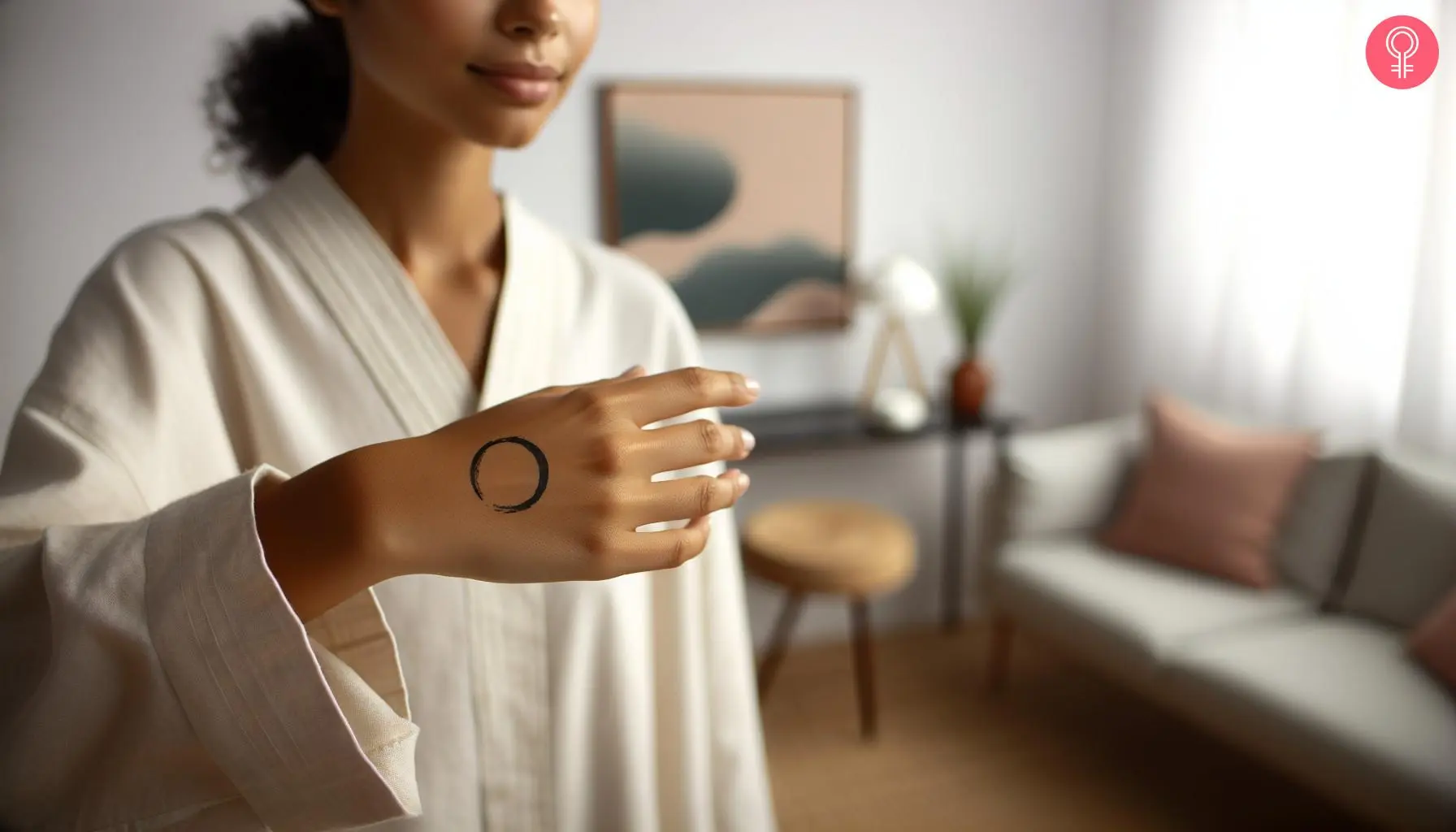 Thin enso tattoo on the back of a woman’s hand