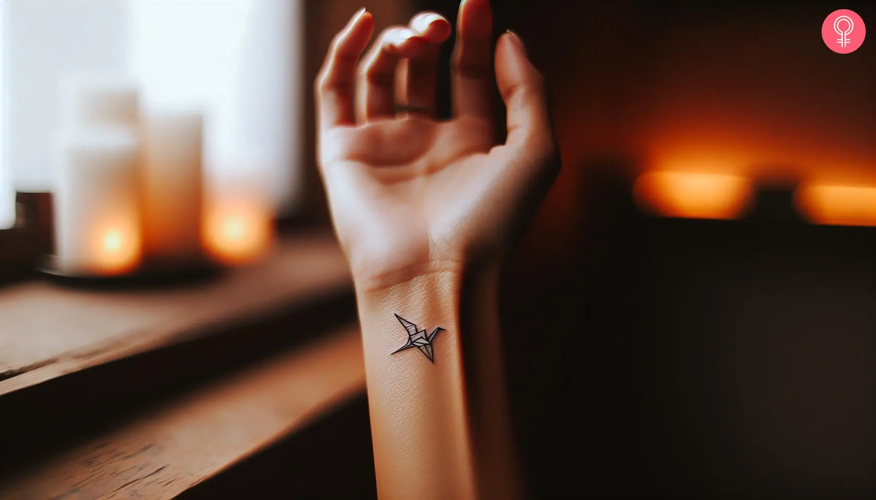 Tiny paper crane tattoo on the wrist of a woman