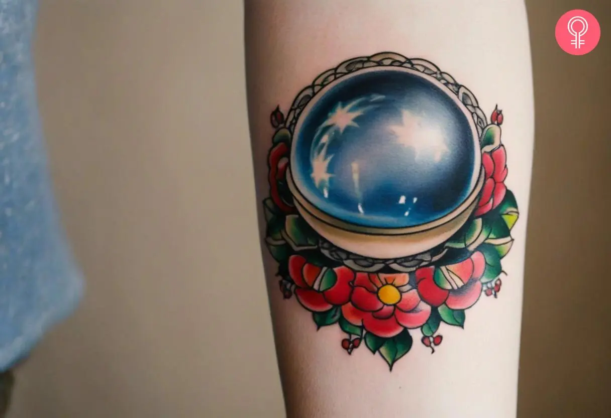 A woman with a traditional crystal ball tattoo on her arm