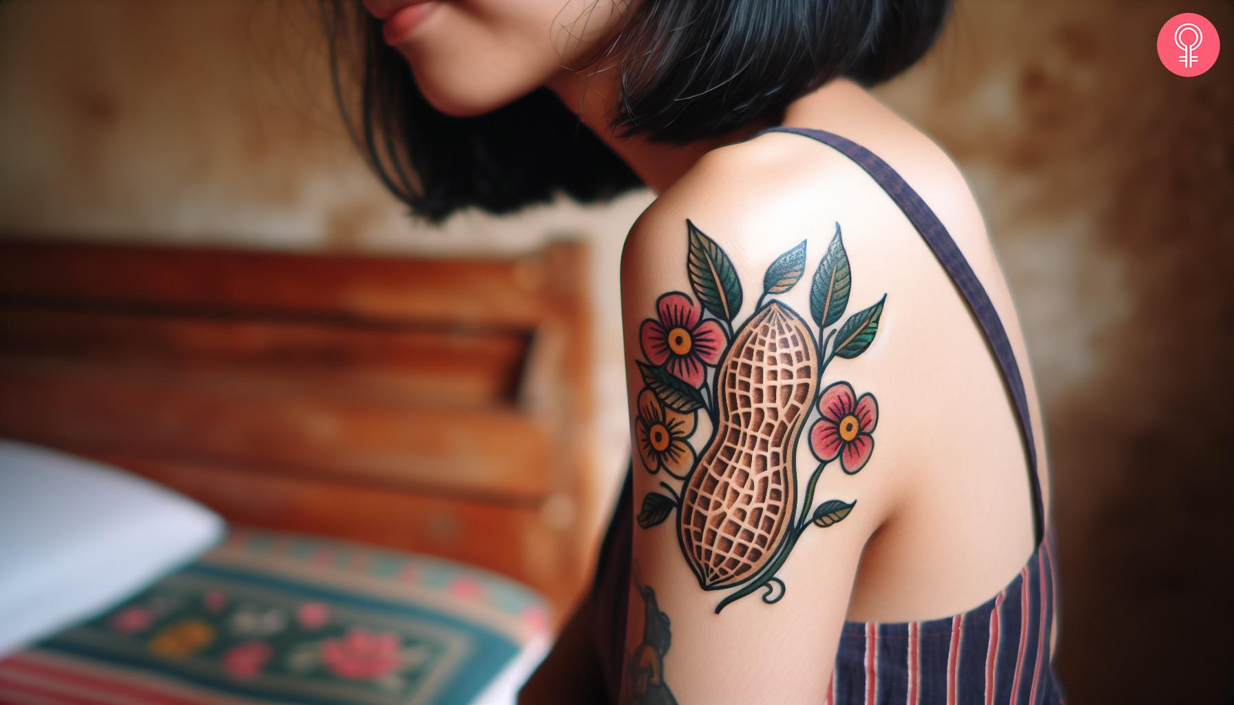 Traditional peanut and flowers tattoo on the shoulder