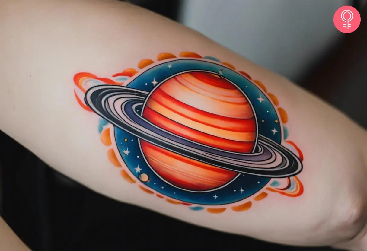 A traditional saturn tattoo on the back of a woman’s upper arm