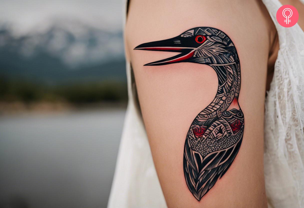 A tribal loon tattoo on the upper arm