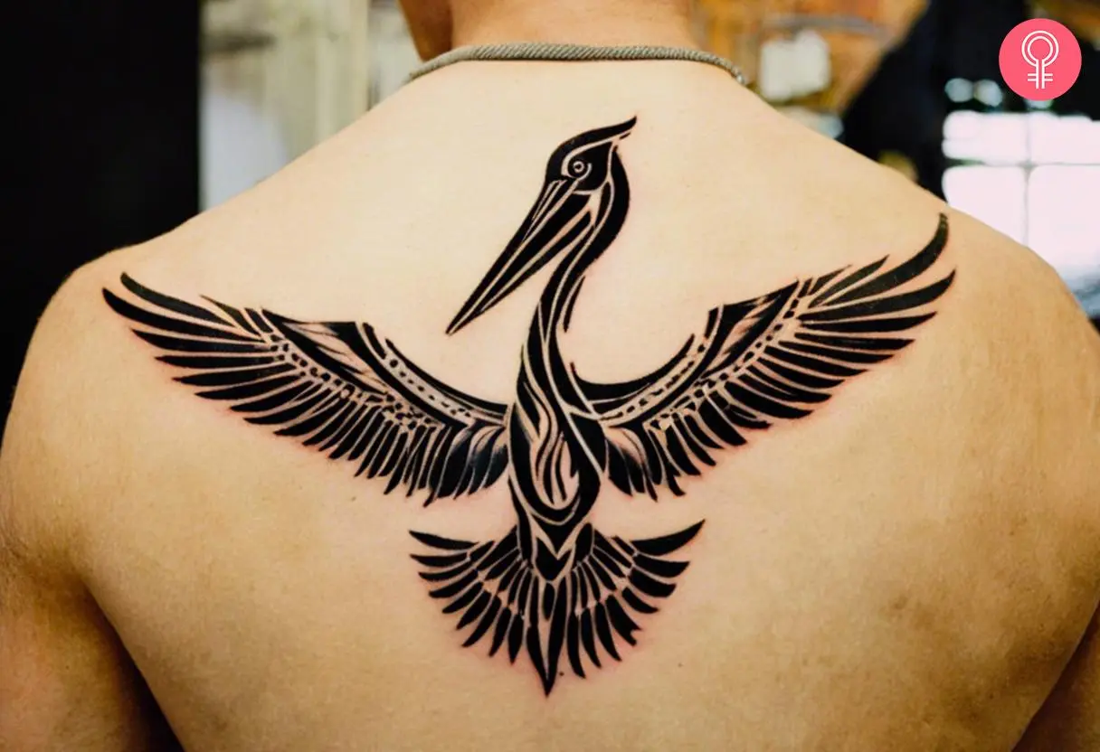 A tribal Pelican tattoo in black ink on the back