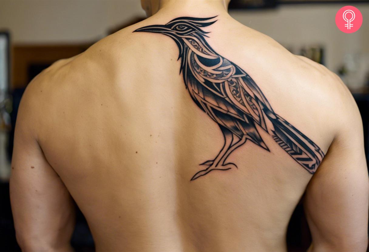 A man wearing a tribal roadrunner tattoo on the back.