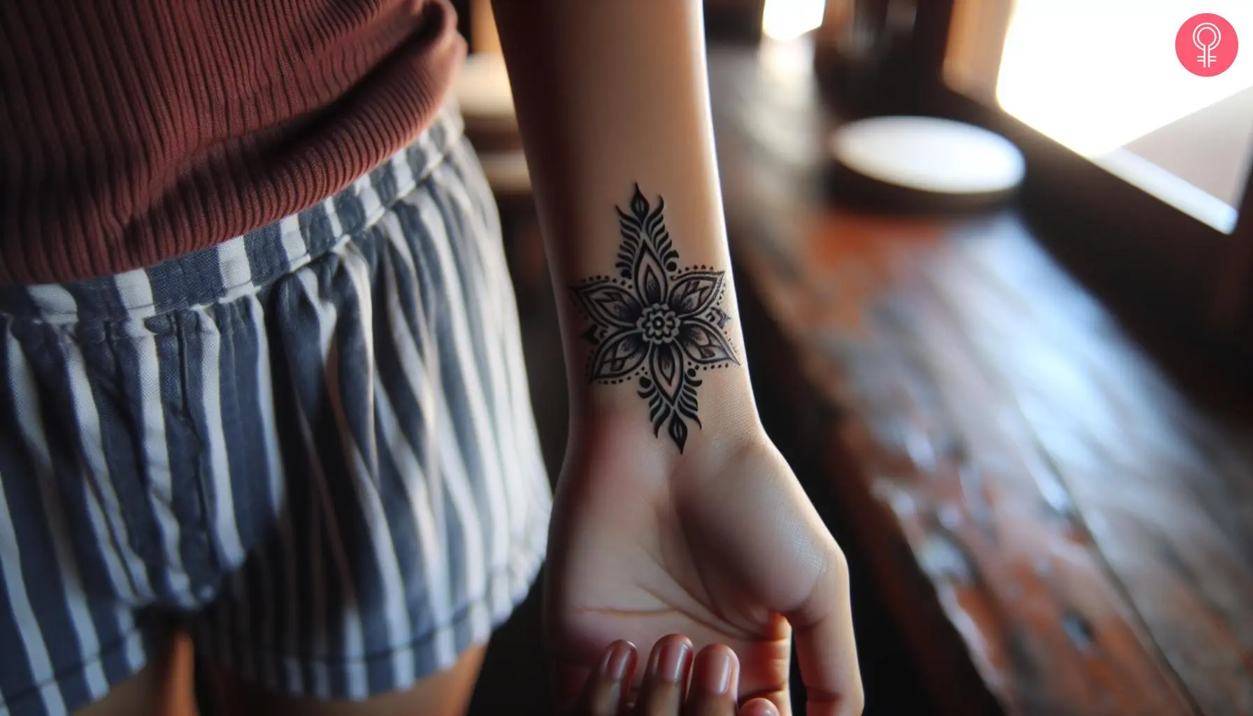 Tribal flower tattoo on the wrist of a woman