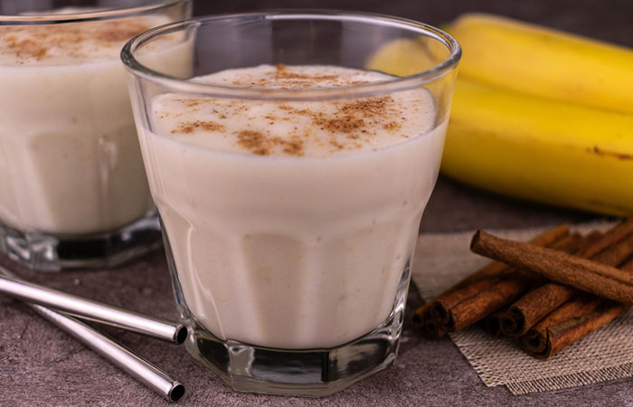 Two glasses of homemade cinnamon roll protein shake on the table