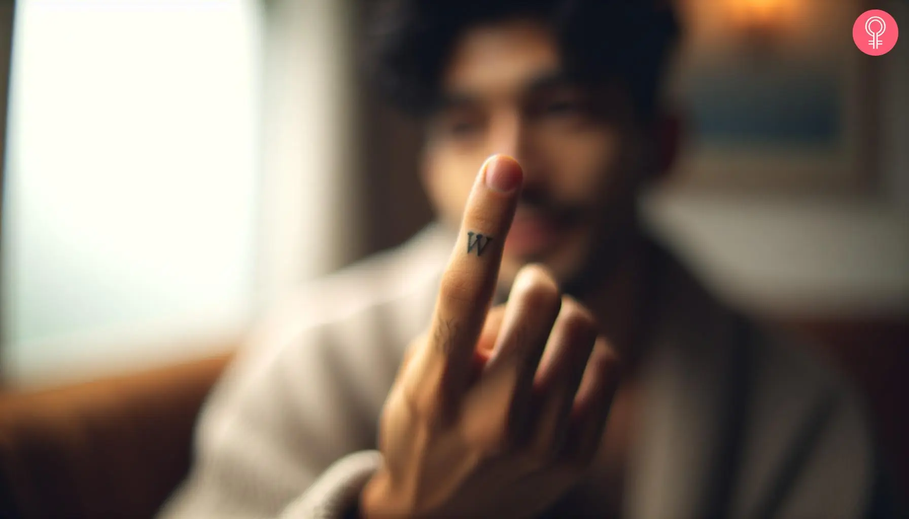 W tattoo design on the finger of a ma