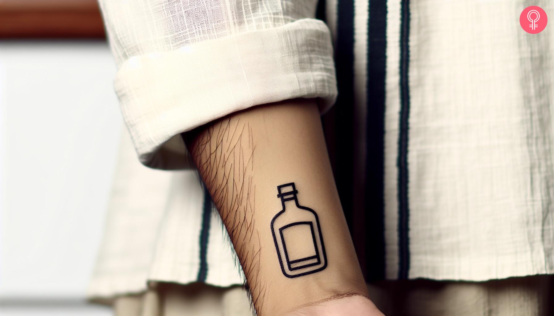 A minimalist whiskey bottle tattoo on the wrist