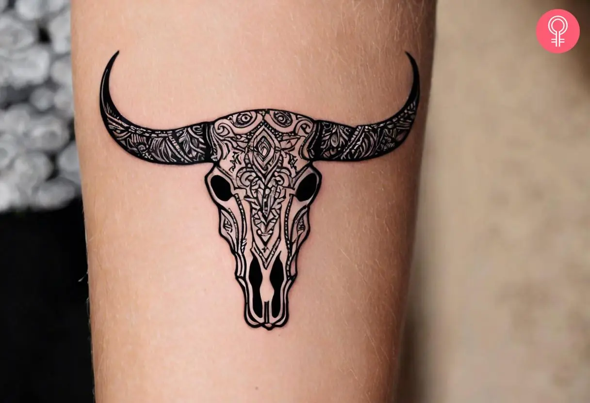 Woman wearing a tribal bull skull tattoo on the forearm