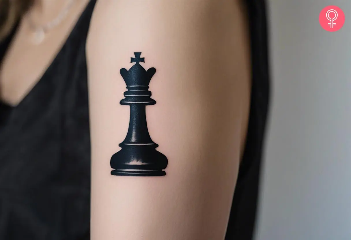 Woman with a black king chess piece tattoo