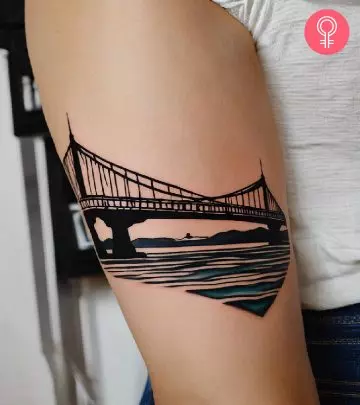 A woman sporting a bold graphic tribal cross tattoo on her arm