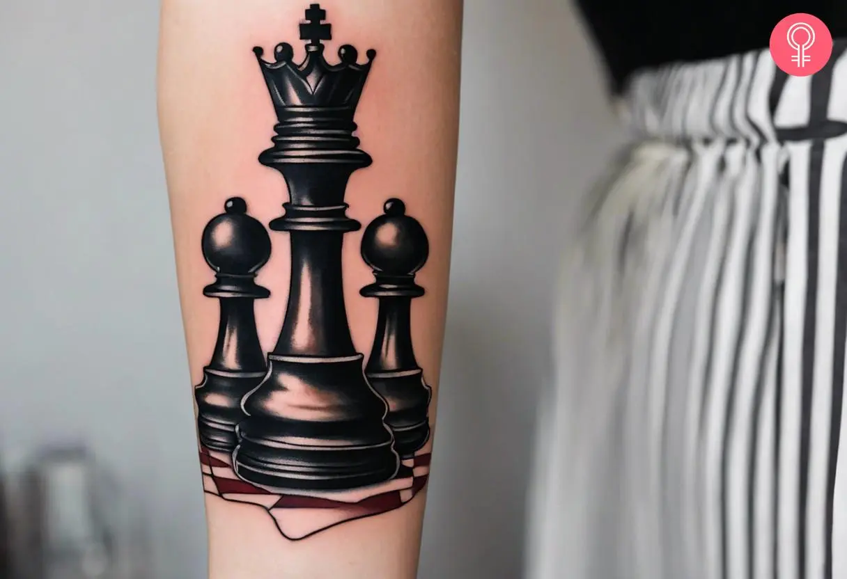 Woman with a king chess piece forearm tattoo