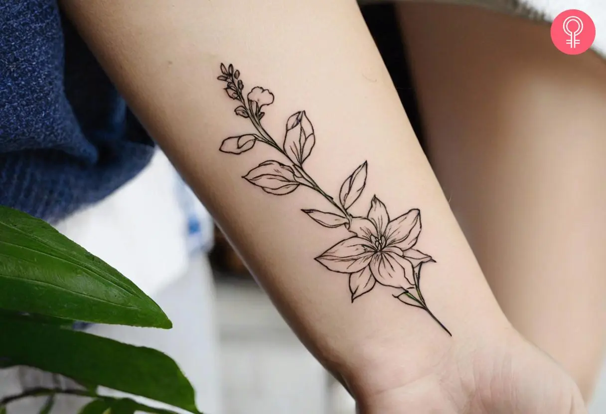 Woman with a tattoo of the larkspur flower near her wrist