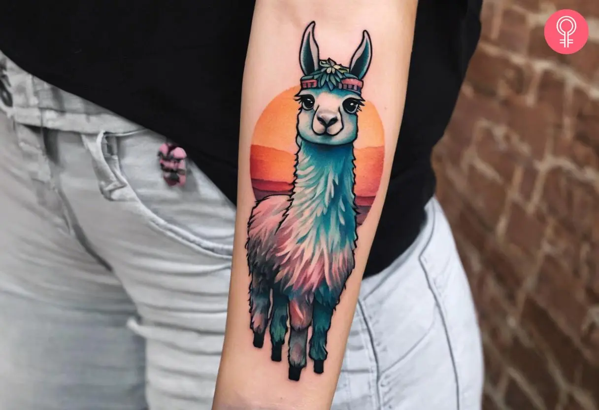 Woman with an adorable colorful llama with a sunset background inked on the forearm