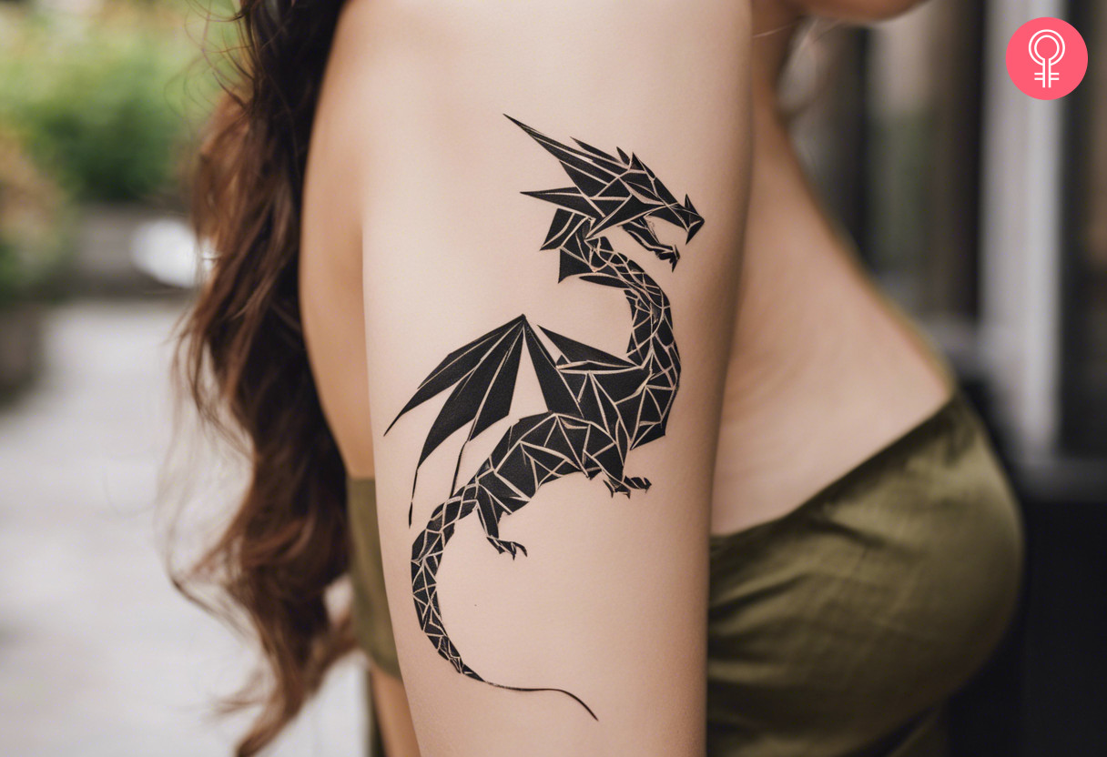 Woman with an origami dragon tattoo on the upper arm
