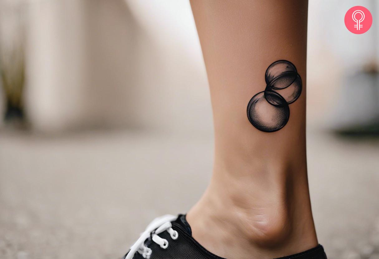 Woman with black and white bubble tattoo on her ankle