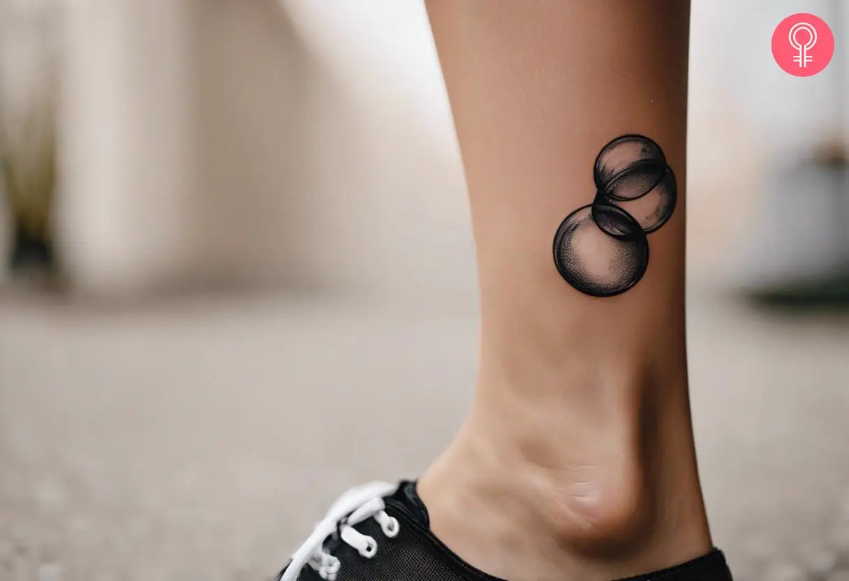 Woman with black and white bubble tattoo on her ankle