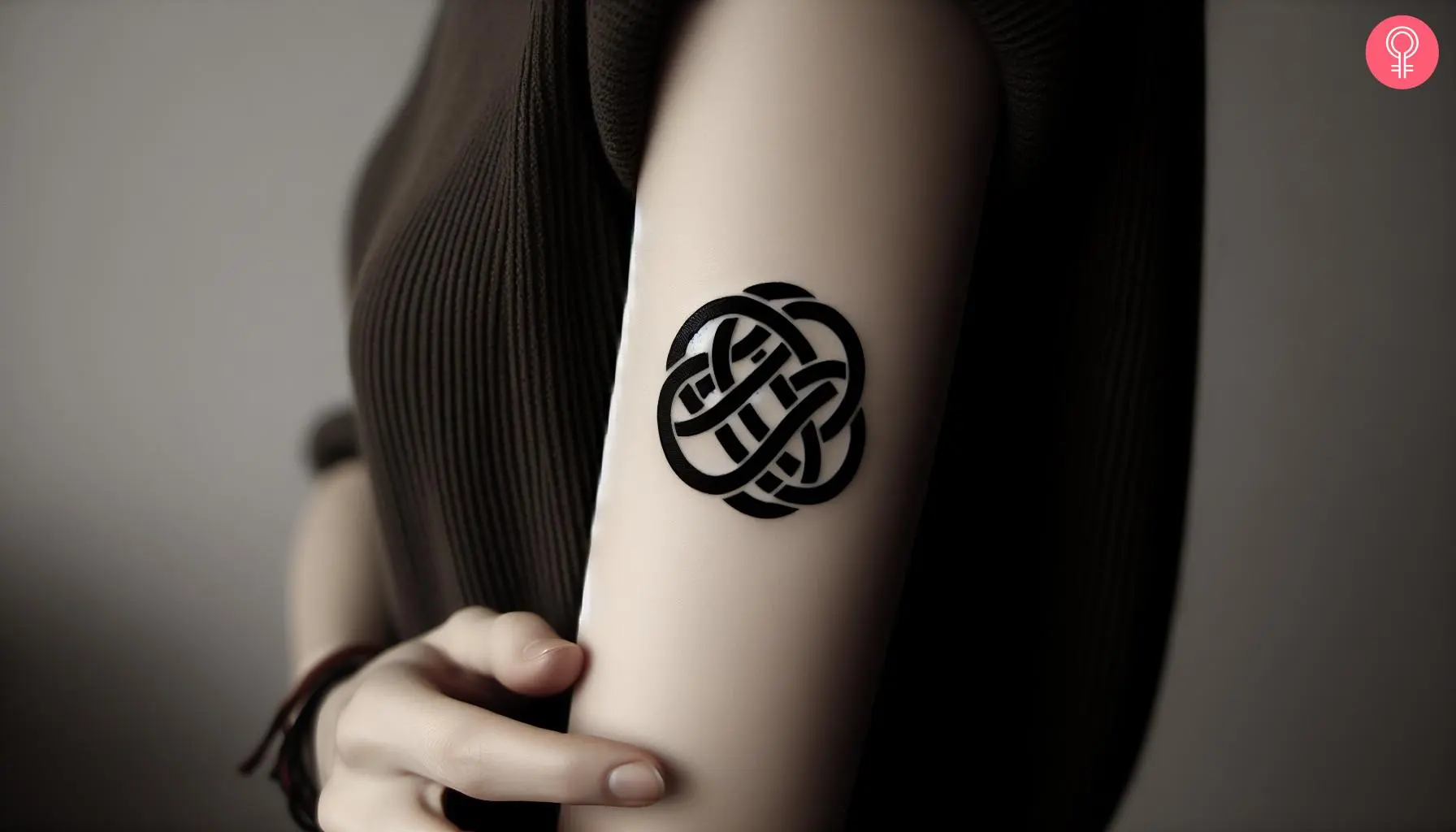 Woman with celtic shield knot tattoo on her outer arm