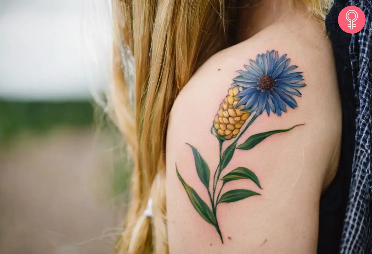 Woman with cornflower tattoo on her outer arm