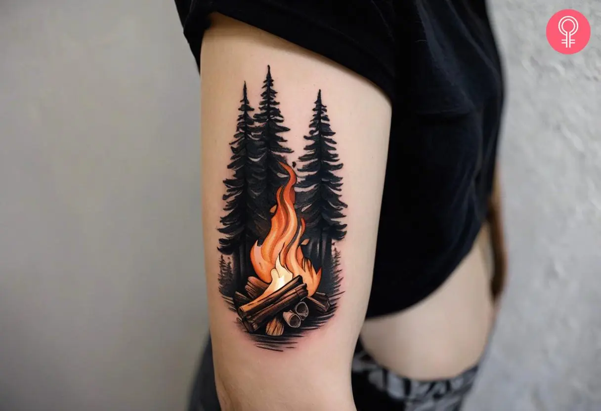 Woman with forest campfire tattoo on her upper arm