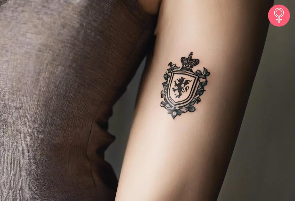 Woman with minimal family crest tattoo on her outer arm