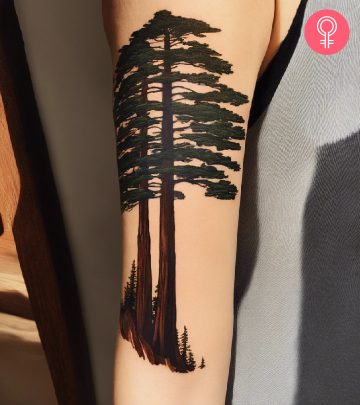 A woman with a colored mountain and trees scenery tattoo on her upper arm