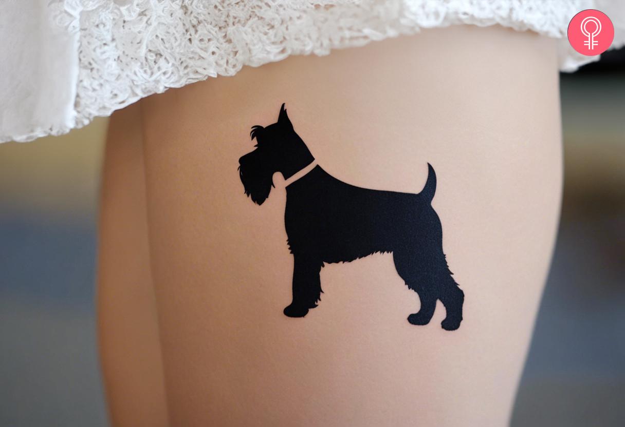 Woman with schnauzer silhouette tattoo on her thigh