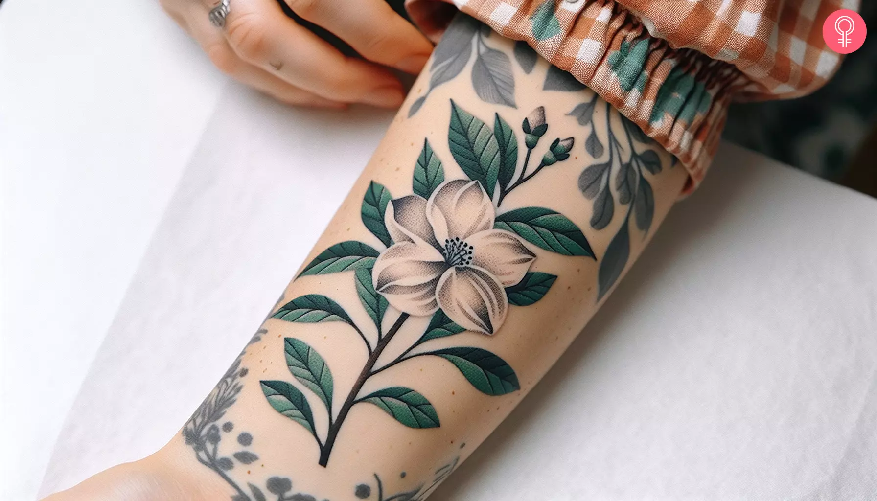 Woman with white gardenia tattoo on her forearm