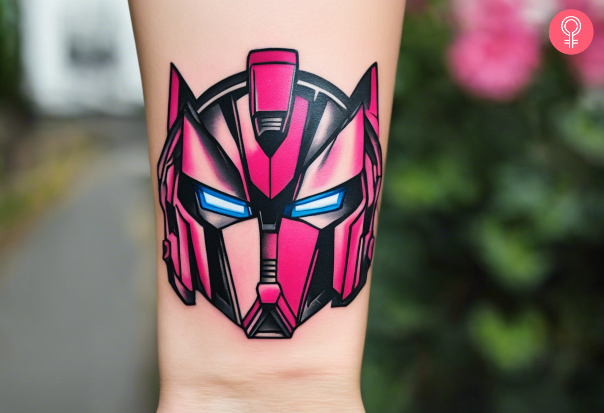 A pink transformer tattoo of arcee on the wrist