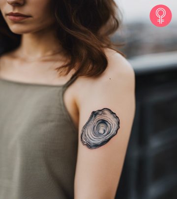 A woman with a vibrant Japanese frog tattoo on her upper arm