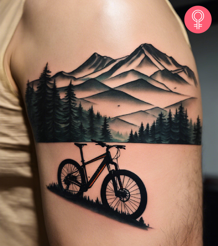 Man with a bike and mountains tattoo on the upper arm