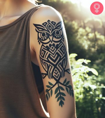 A woman with a black tribal bird tattoo on her upper arm