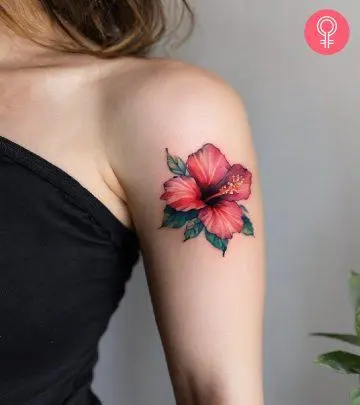 A woman with a hibiscus tattoo on her upper arm